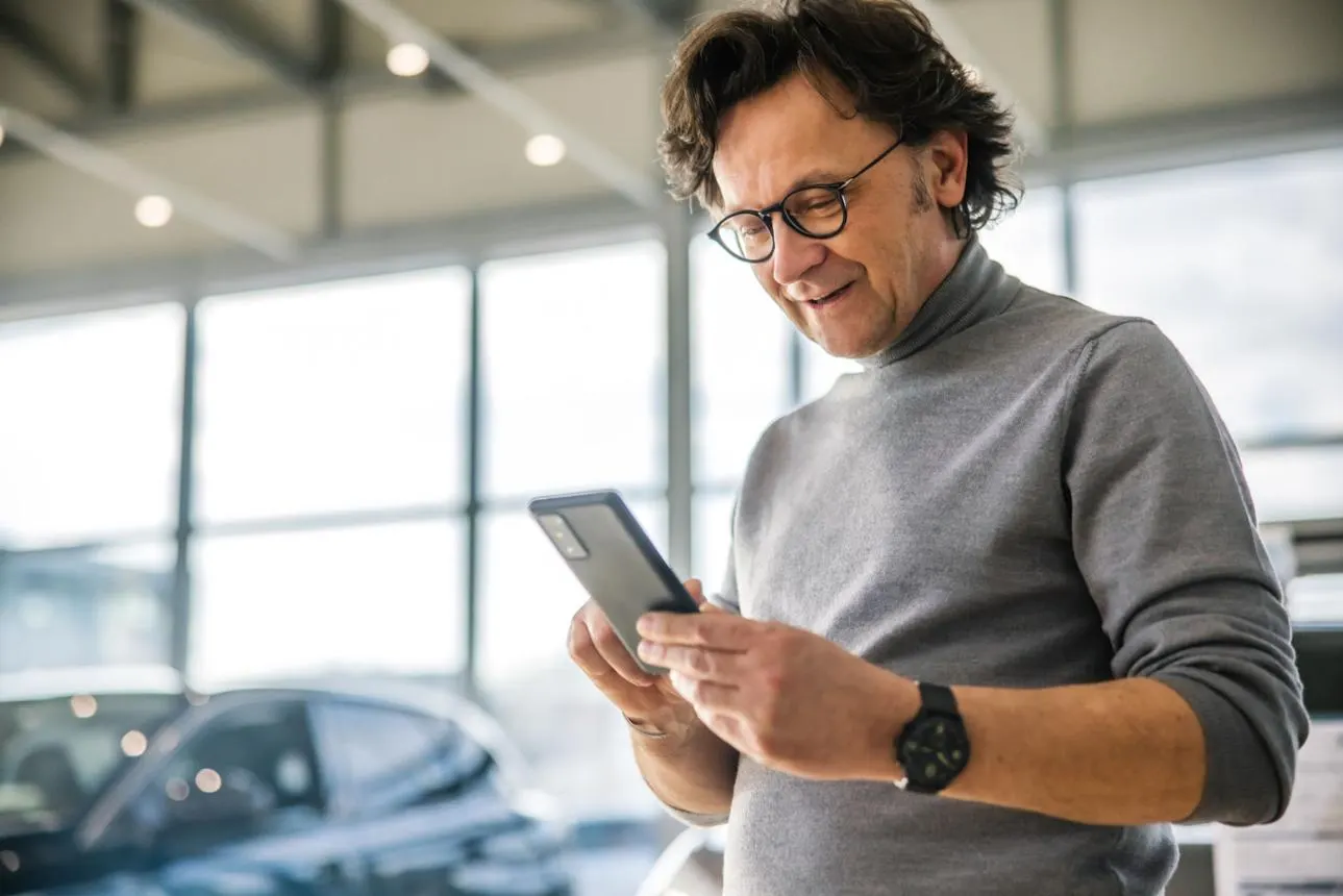 Cliente revisando su oferta para vender el carro en Dallas desde su teléfono